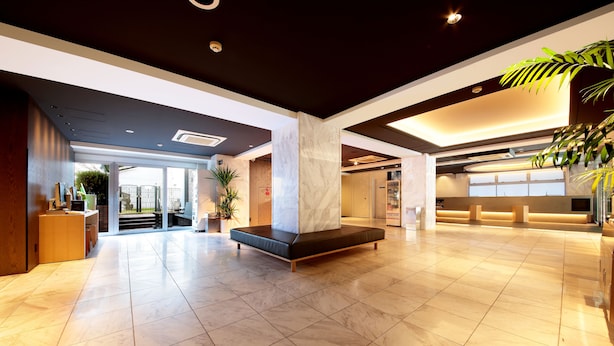 A spacious lobby with a central seating area, a reception desk, and a large plant. - Hotel Asia Center of Japan (Tokyo)