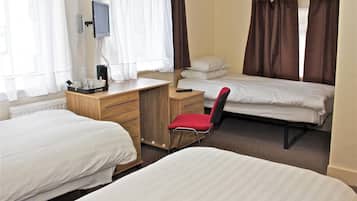 A hotel room with two single beds, a desk with a chair, a television, and a window with curtains.
