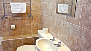 A bathroom with a toilet, sink, and towel rack.