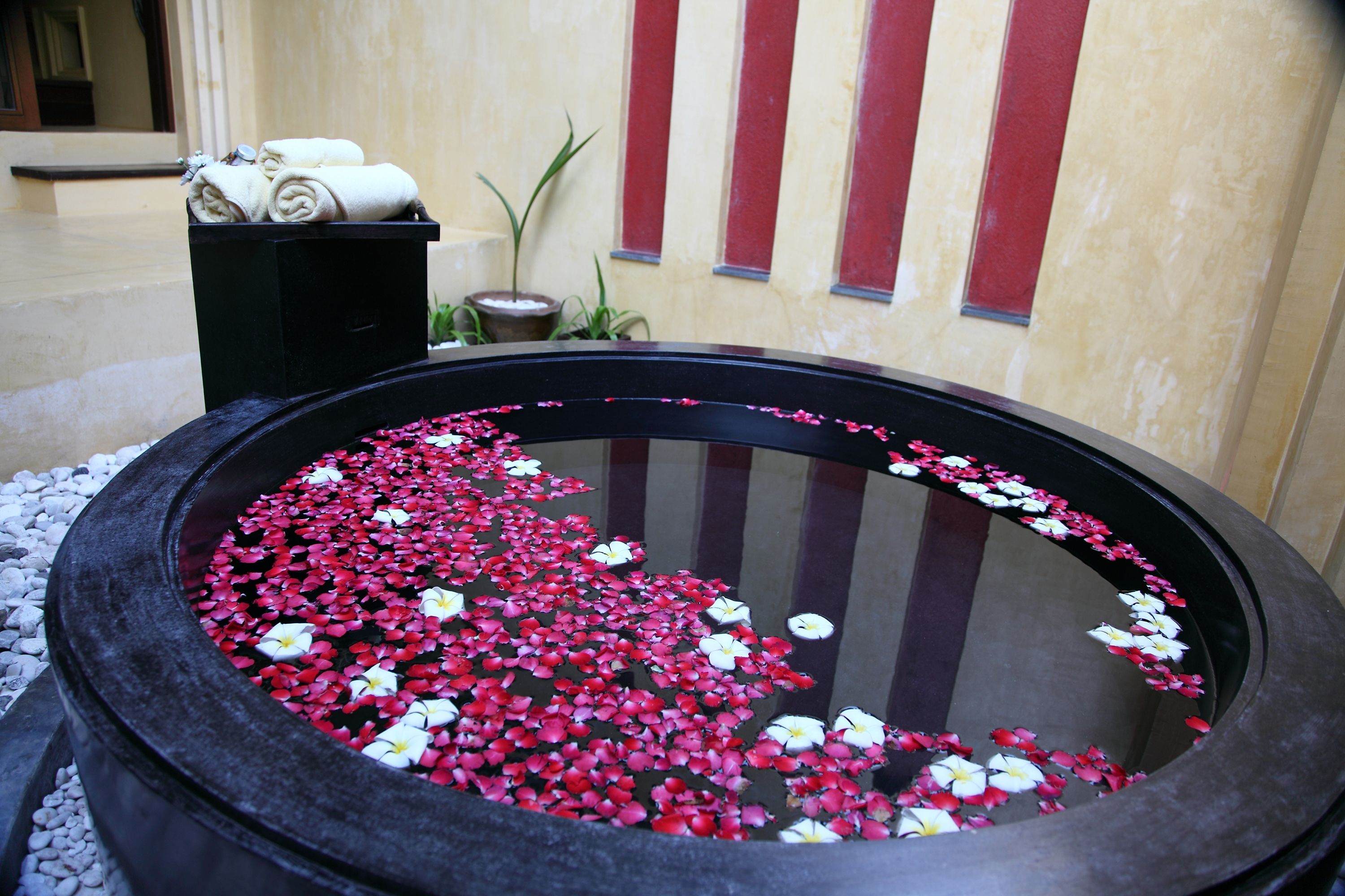 A circular water feature with floating flower petals and a black basin.