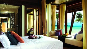 Une chambre d’hôtel avec un lit, un canapé et une vue sur l’océan.
