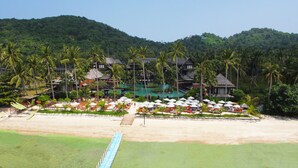 A resort with multiple buildings, a swimming pool, and a beach area with umbrellas and lounge chairs. - Mai Samui Beach Resort & Spa (Koh Samui)