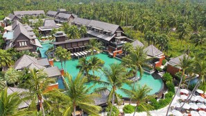 A resort with multiple buildings, a central swimming pool, and surrounding palm trees. - Mai Samui Beach Resort & Spa (Koh Samui)