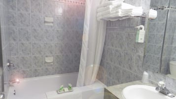 A bathroom with a bathtub, a sink, and a shower curtain.