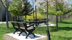 A park with two benches, a picnic table, and a lamp post. - Capri Inn (St. Catharines)