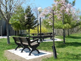 A park with two benches, a picnic table, and a lamp post.