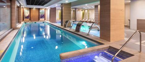 A swimming pool with a tiled edge, a changing room area, and a reception desk.