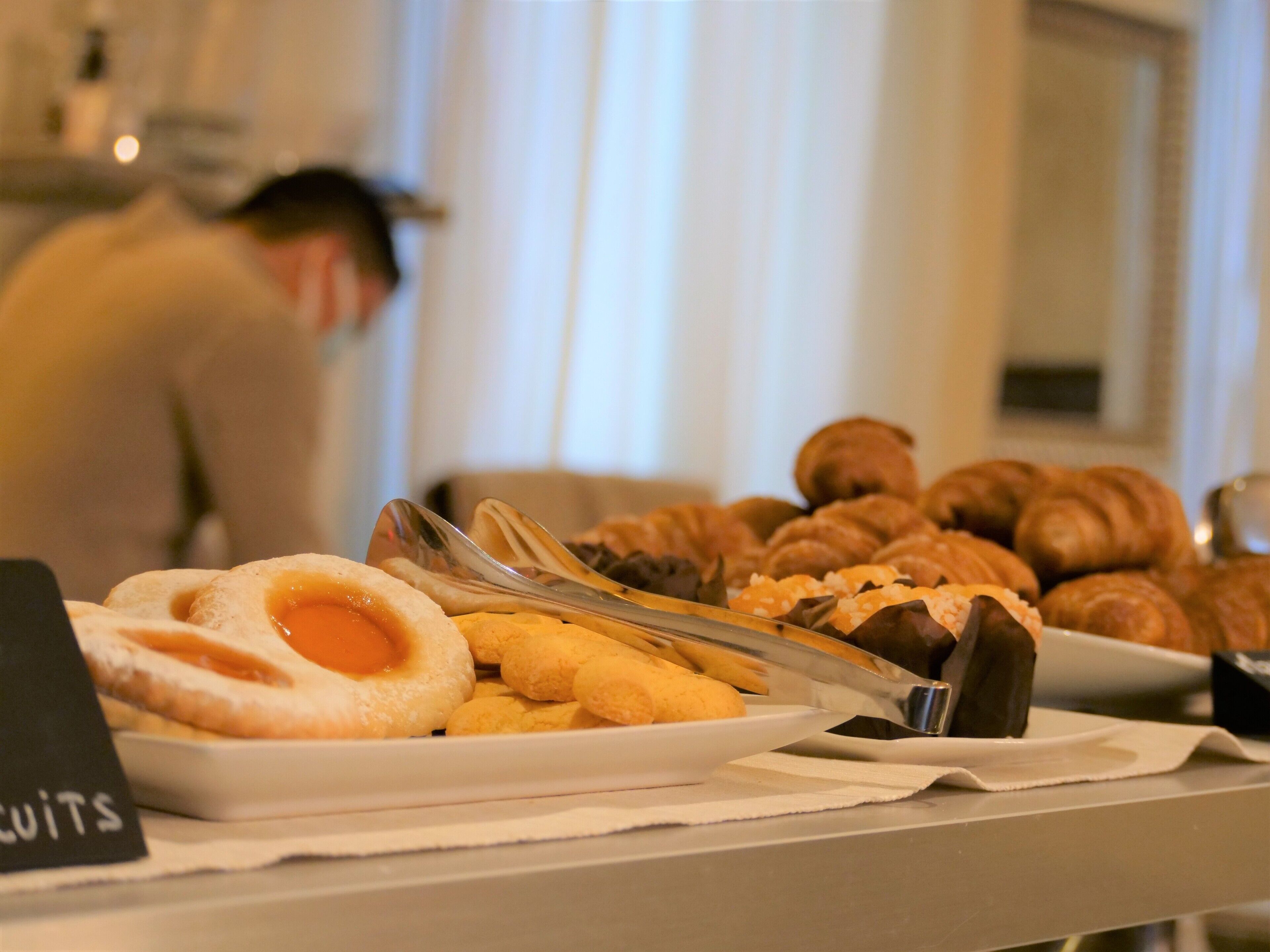 A buffet table with various pastries and a sign labeled "CUITS".