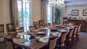 A dining area with a large round table set for a meal, surrounded by wooden chairs. - Hotel Patavium (Padova)