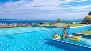 A swimming pool with clear blue water, a view of the cityscape, and a distant coastline. - Beppu SUGINOI HOTEL（ORIX HOTELS & RESORTS） (Beppu)