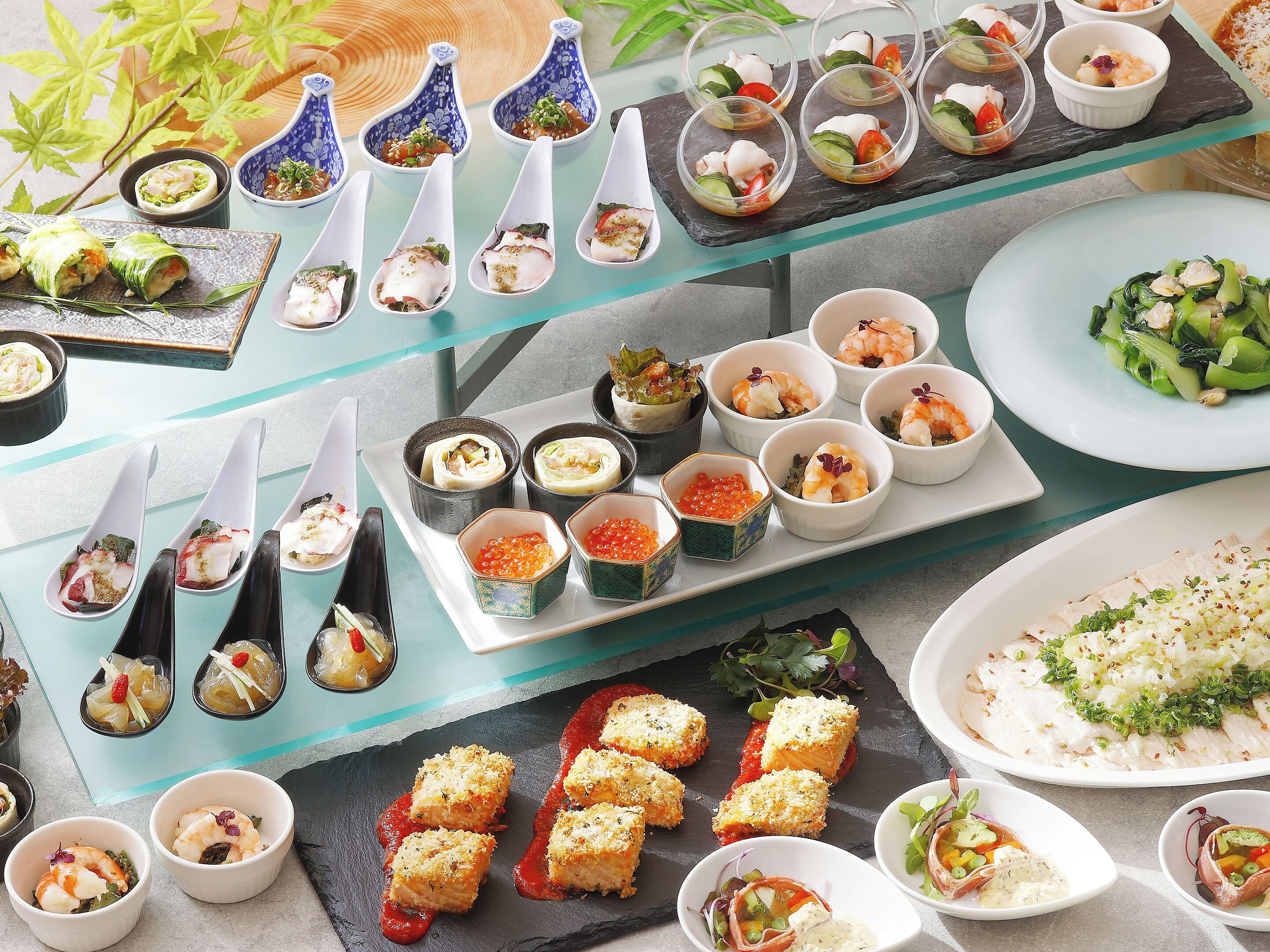 A variety of dishes arranged on a table, including sushi, sashimi, and other appetizers.