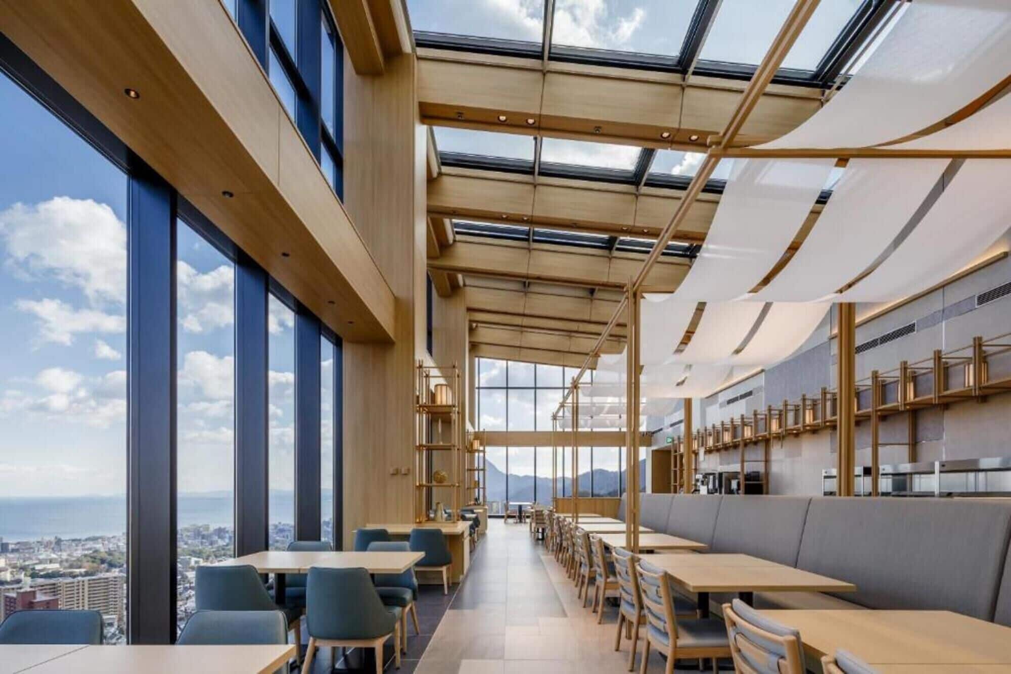 A modern restaurant with large windows, wooden beams, and a view of the city.