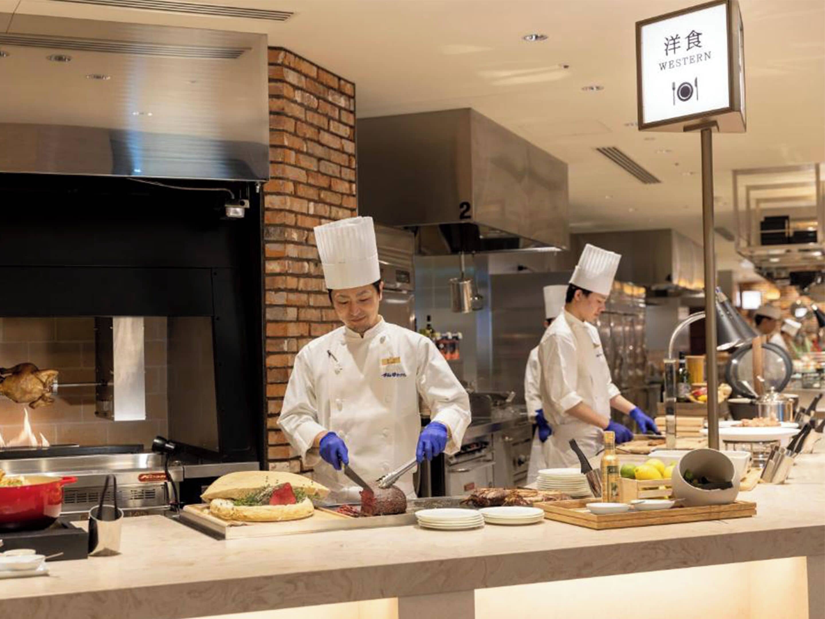 A professional kitchen with chefs preparing food, a brick wall, and a sign indicating 'Western' cuisine.