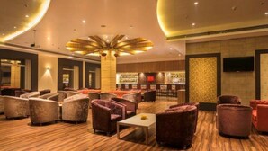 A lobby with seating areas, a bar, and a television screen.