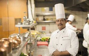 Expert chefs prepare meals in a well-equipped kitchen with stainless steel appliances and utensils.