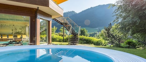 Una piscina techada, una piscina al aire libre, sombrillas