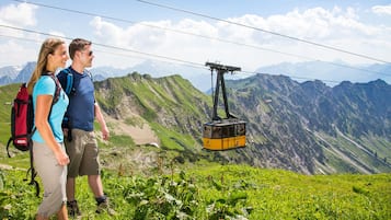 Eine Seilbahn in einer gebirgigen Landschaft bei strahlendem Himmel.