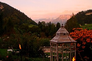 Un pabellón en un valle exuberante con vistas a montañas distantes.