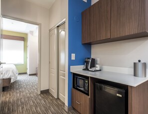 A compact hotel room with a kitchenette, including a microwave, coffee maker, and a refrigerator. - Holiday Inn Express & Suites Lagrange I-85 by IHG (LaGrange)
