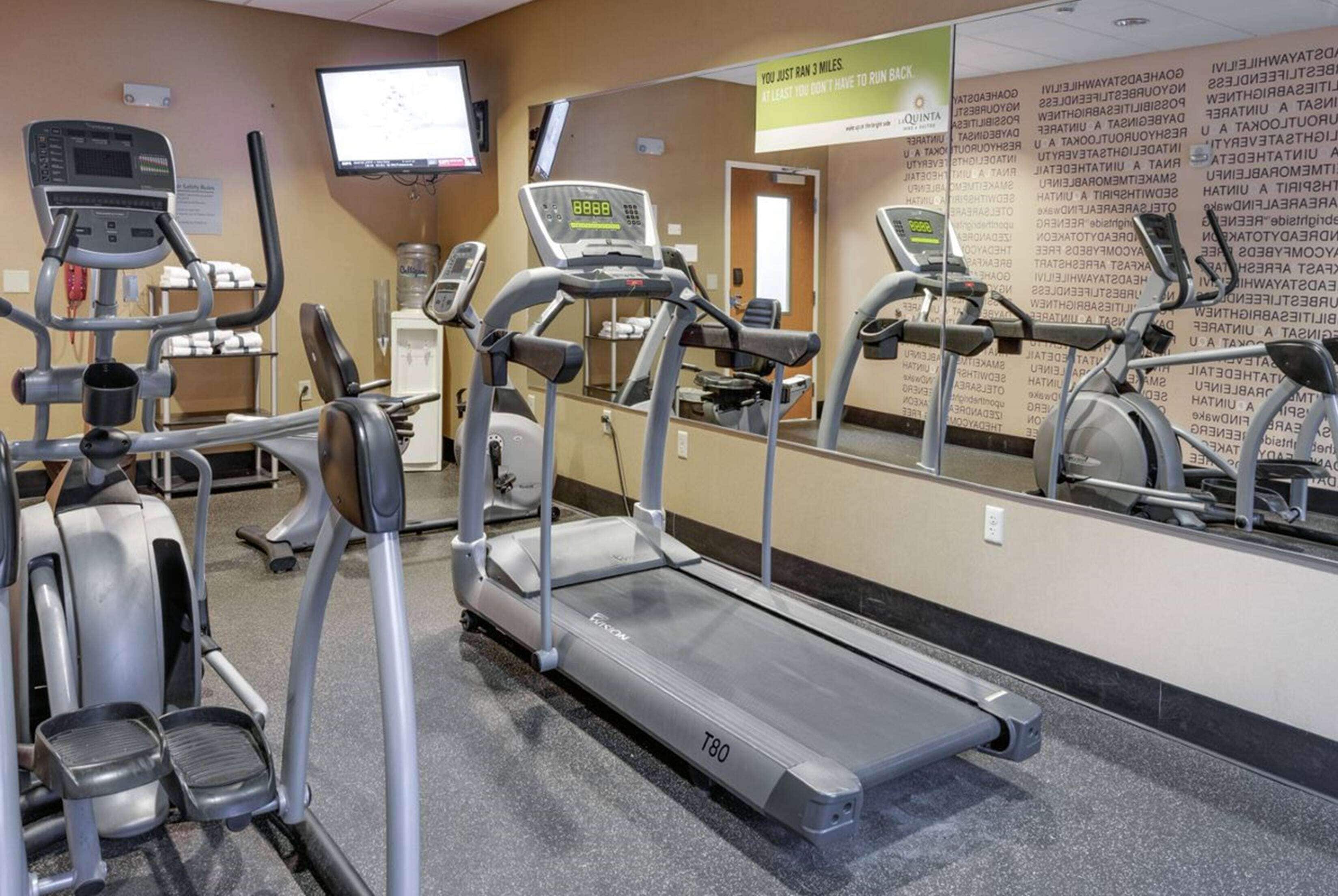 A gym with treadmills, an elliptical, and a stationary bike.