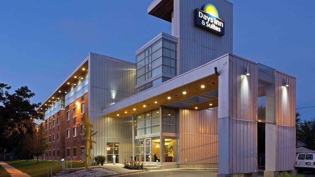 Edificio de Day Inn & Suites de diseño moderno, con amplias ventanas y un cartel llamativo.
