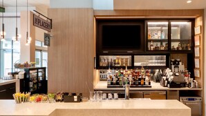 Un coin bar avec une enseigne indiquant « The Placery », une variété de bouteilles d’alcool, des verres et une machine à café.