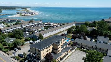 An aerial view of a coastal area with a large hotel building, a beach, and a marina.