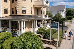 A Colonial Inn with a covered porch, flower boxes, and a signboard. - The Colonial Inn (Ogunquit)
