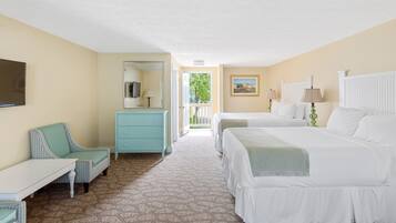 A hotel room with two beds, a desk, a chair, a dresser, and a TV.