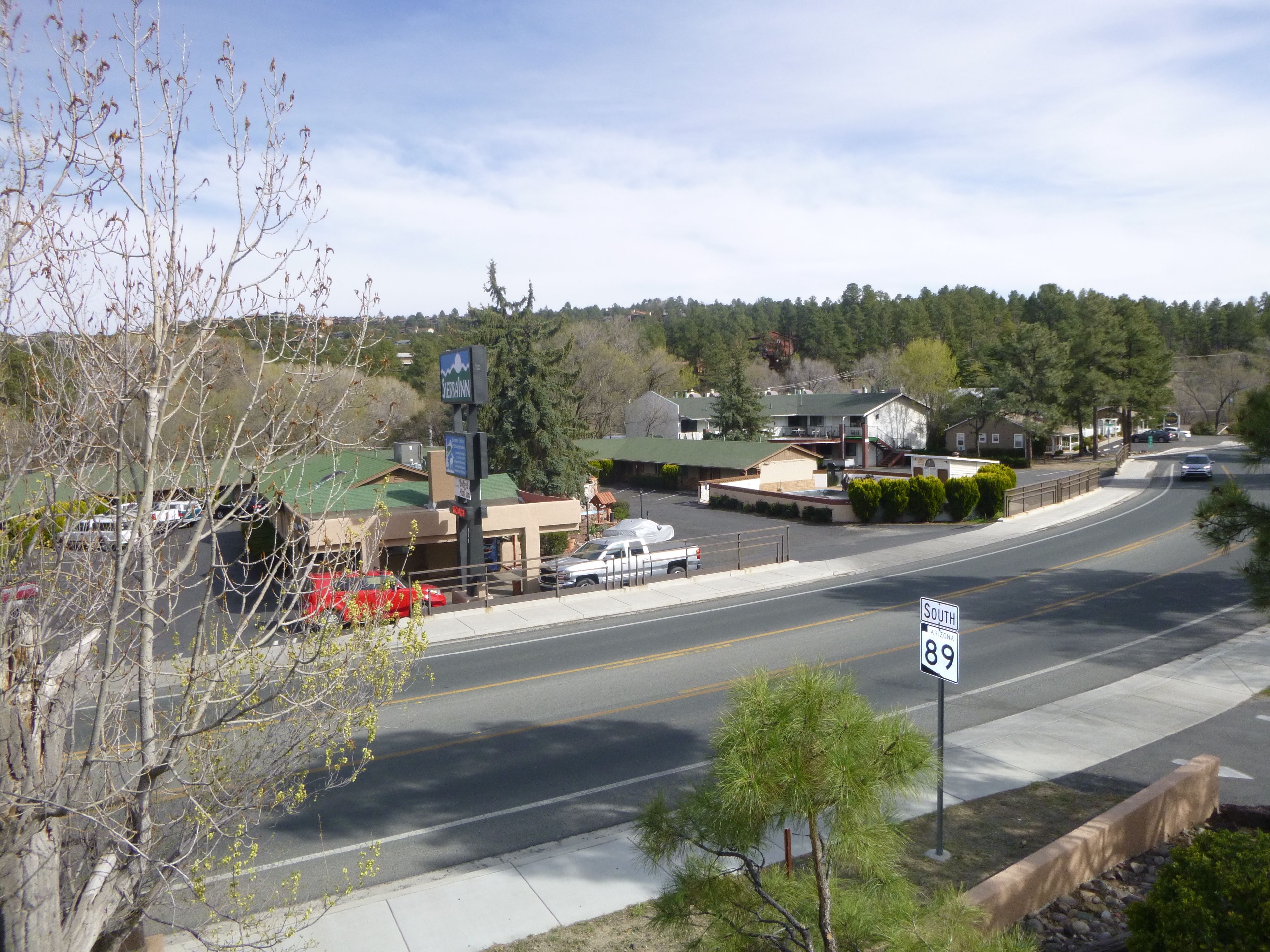 Une vue de rue avec un panneau de signalisation indiquant « Sud 89 » et un établissement commercial appelé « Sierra Inn ».