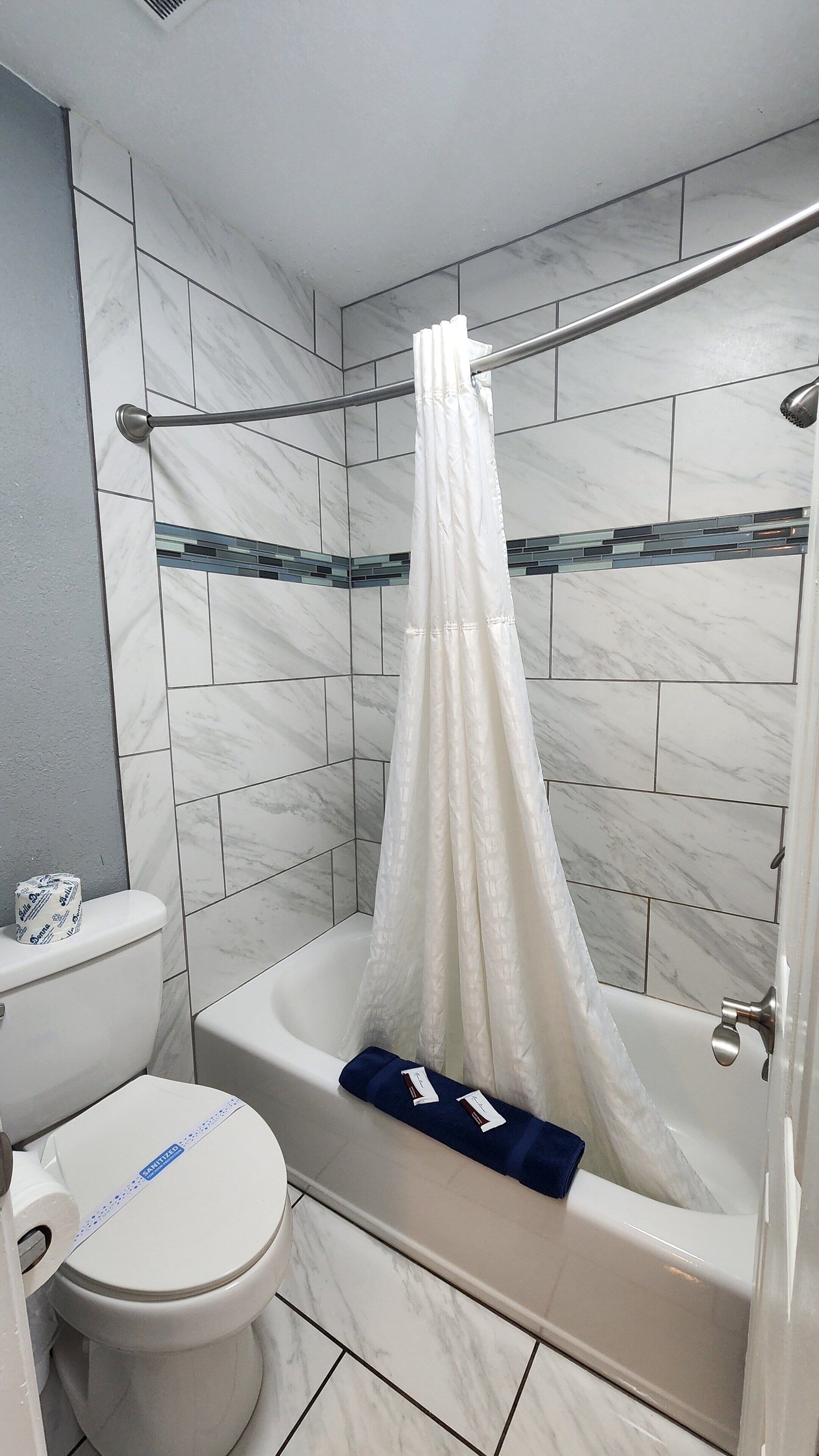 Un bagno con vasca, WC e tenda da doccia.