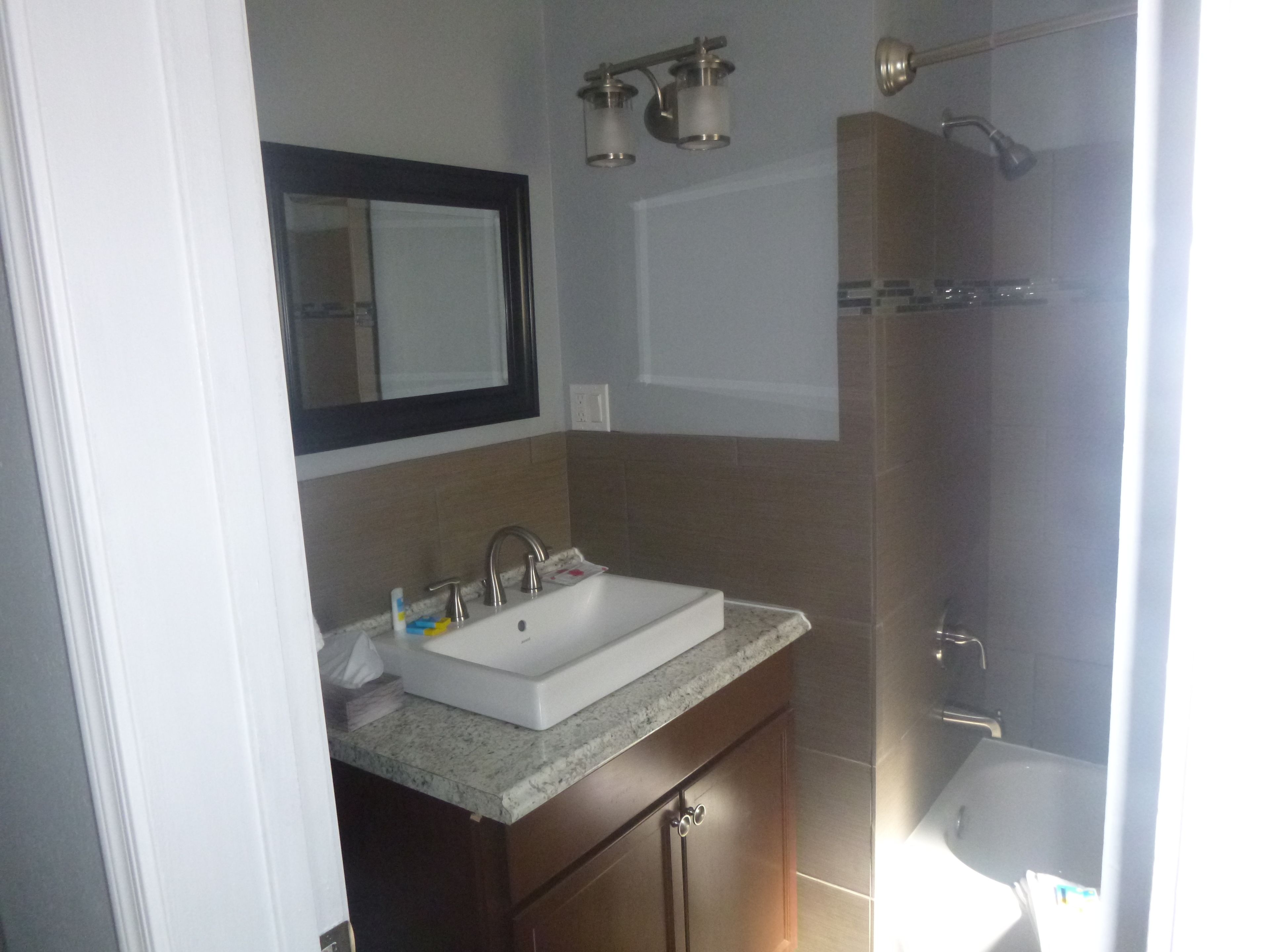 A bathroom with a white sink, a mirror, and a shower.