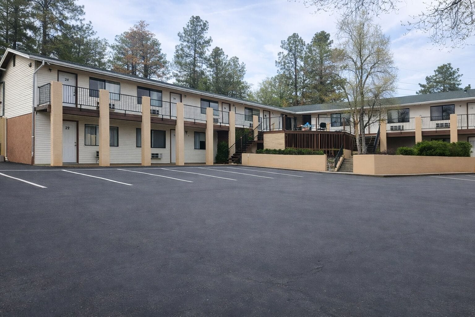 Un motel con cortile centrale, numerosi balconi e un parcheggio.