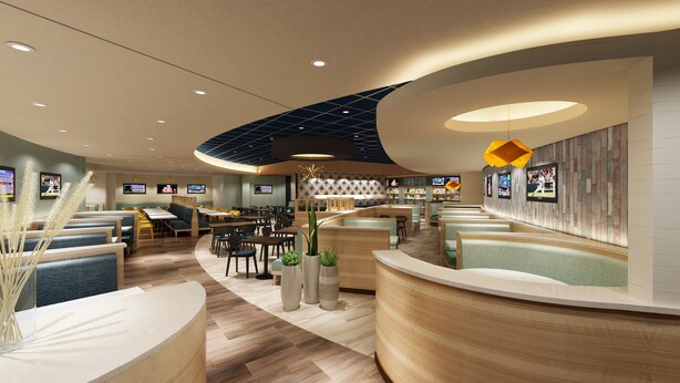 Un restaurant moderne doté de banquettes incurvées, d’un éclairage encastré et d’un bar central.