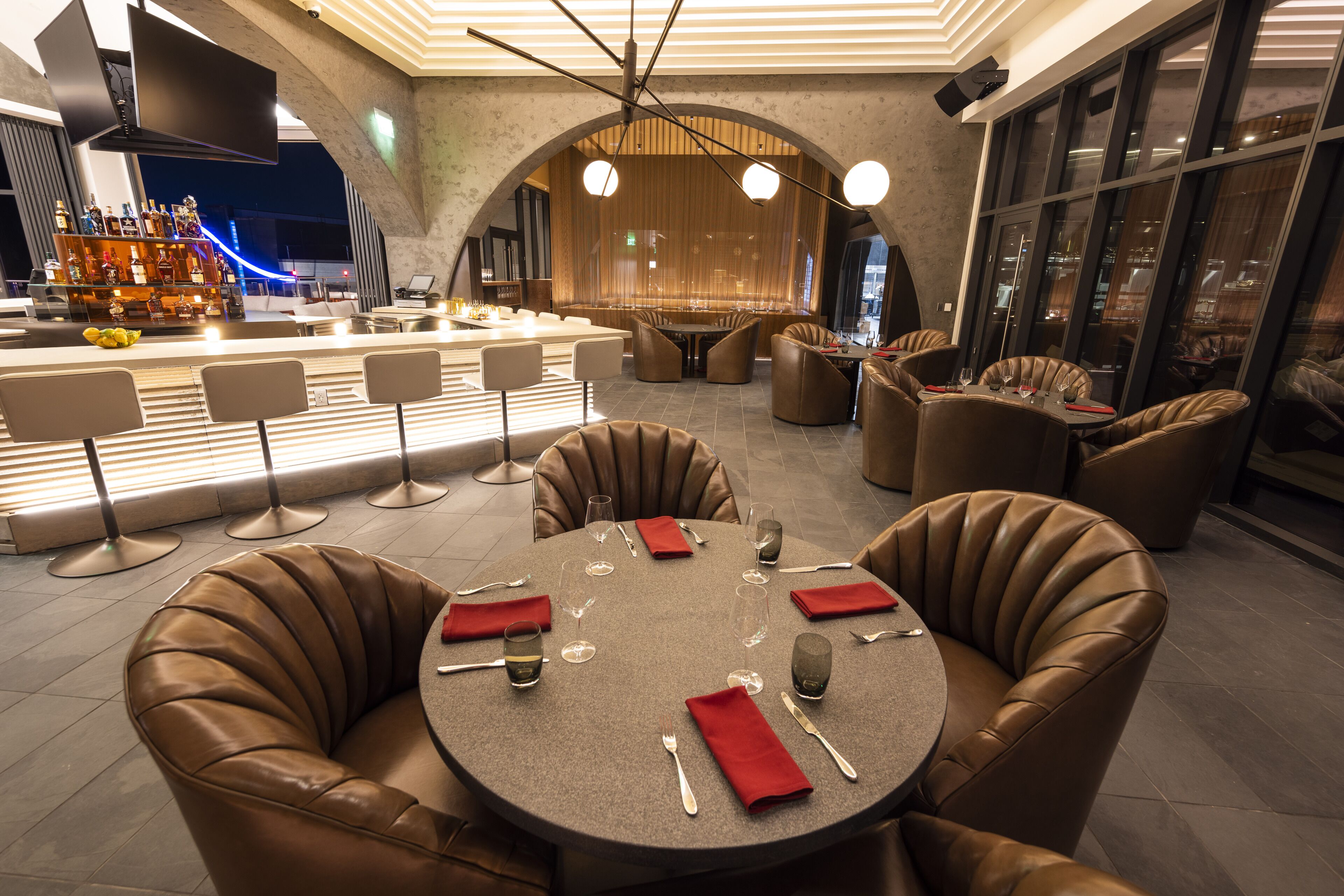 Uma área de bar moderna com balcão, assentos e uma janela ampla.