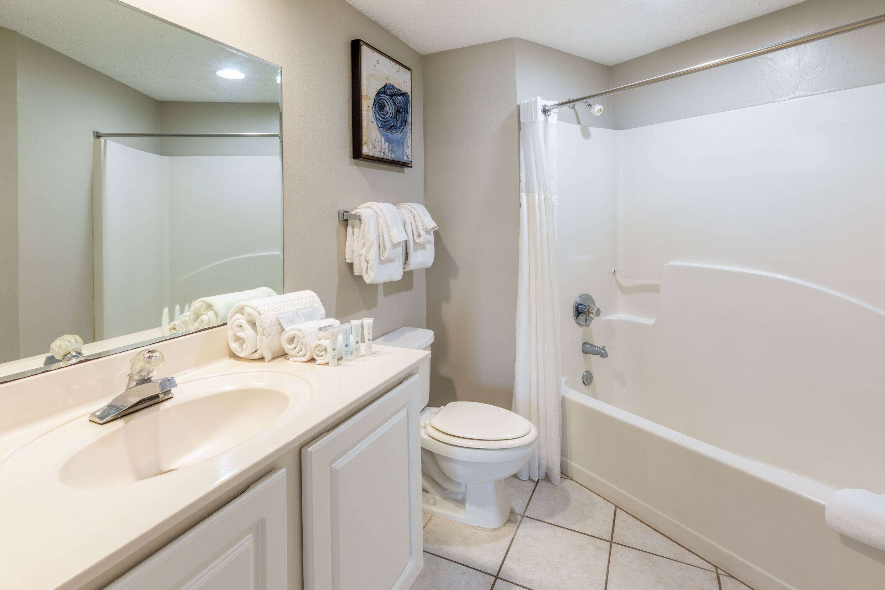 A bathroom with a sink, toilet, and bathtub.