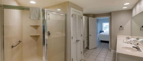 A modern bathroom with a glass shower enclosure, a walk-in bathtub, and a vanity with a mirror.