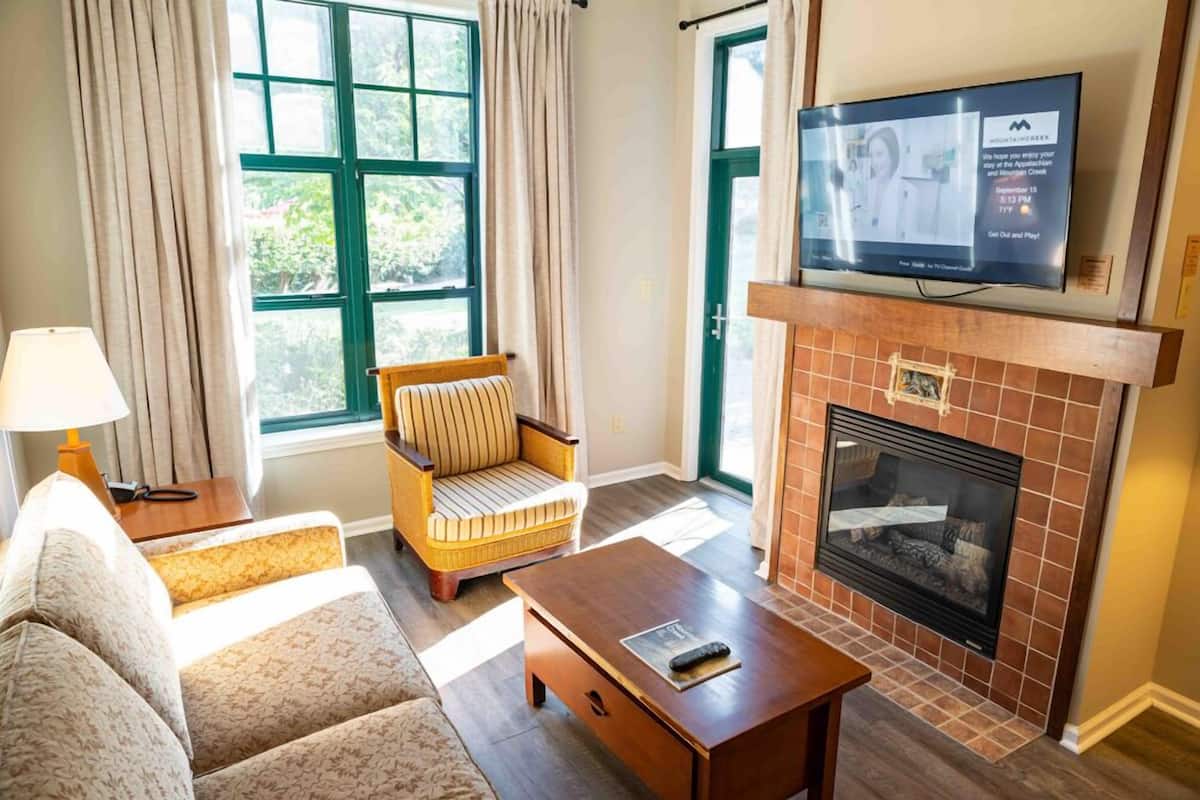 Deluxe Suite, 1 Bedroom, Fireplace | Living area | 55-inch TV with cable channels, table tennis