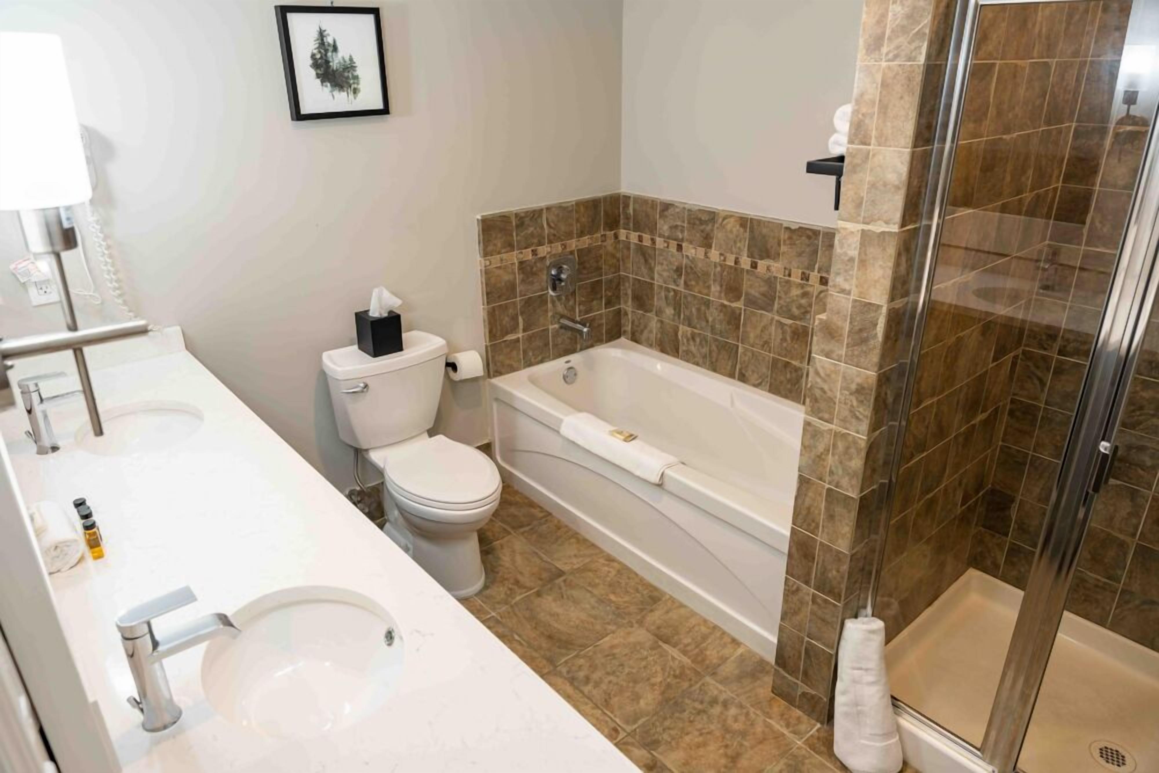 Un baño con lavamanos, inodoro y bañera blancos.