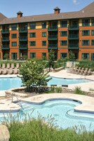 Una piscina al aire libre, sombrillas, sillones reclinables de piscina