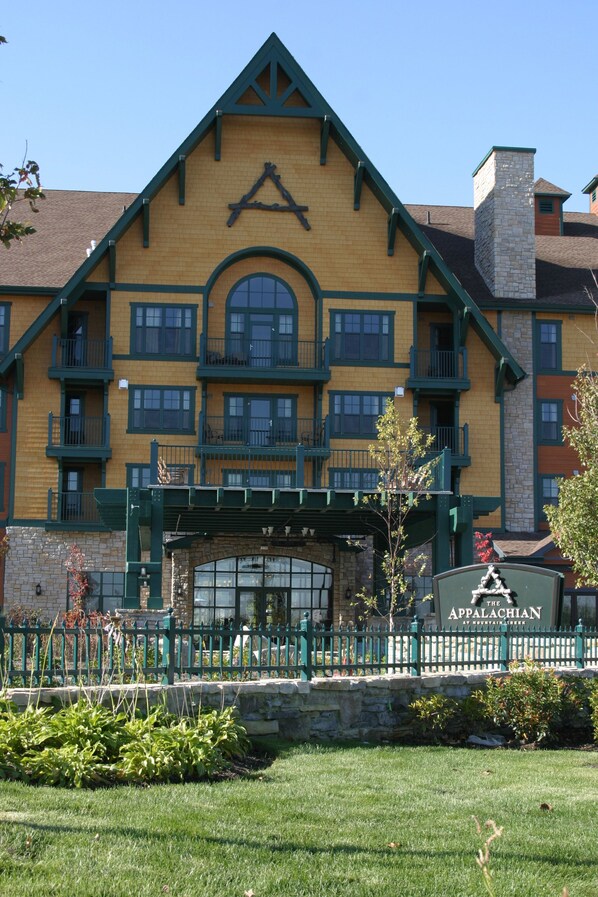 Un edificio de varios pisos con un llamativo logotipo en forma de A en la fachada, una chimenea de piedra y un letrero que dice "The Appalachian".
