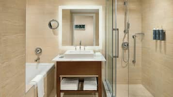 A modern bathroom with a glass-enclosed shower, a white sink, and a wooden vanity.
