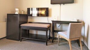 A small, compact room with a desk, chair, and a flat-screen TV mounted on the wall. - King Edward Hotel  (Banff)