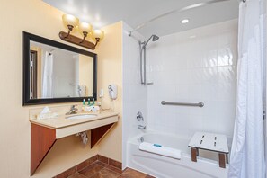 Un baño moderno con lavamanos, espejo y ducha.