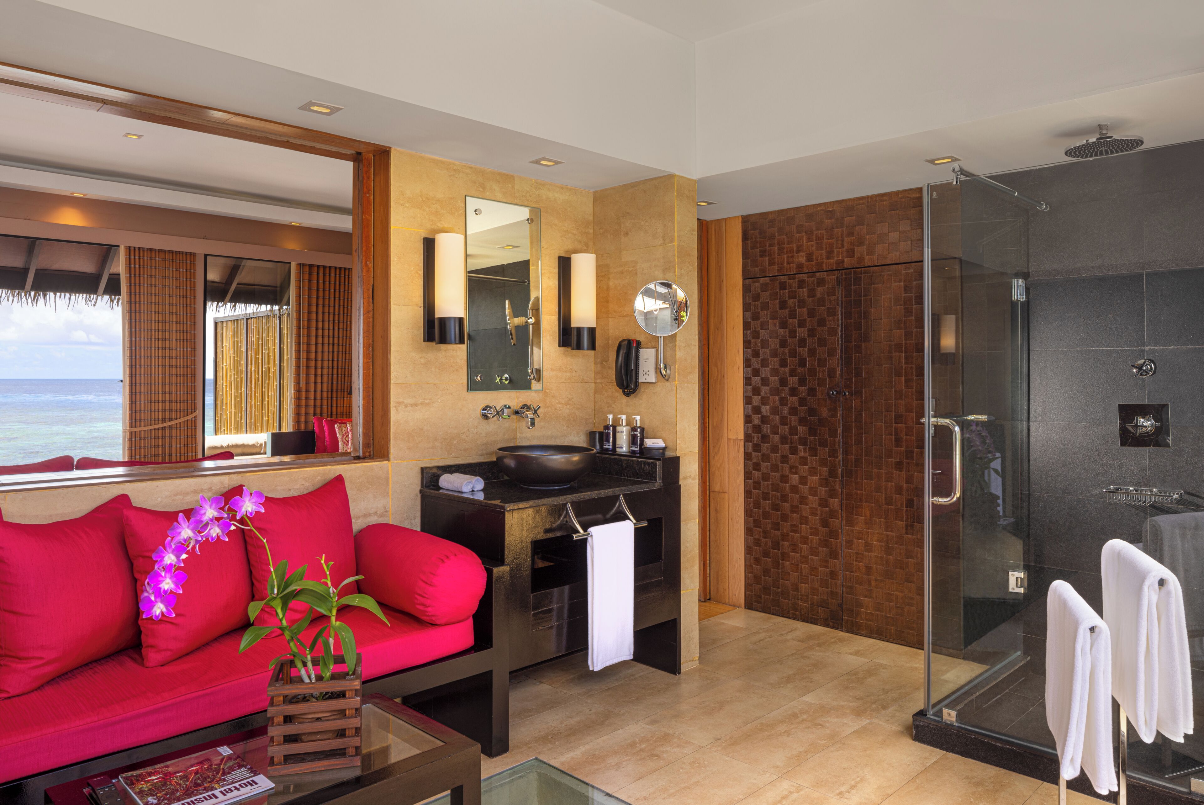 A modern bathroom with a glass shower, a sink with a mirror, and a towel rack.