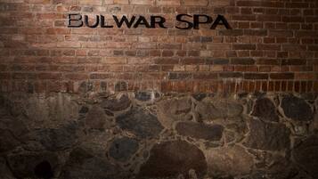 Un muro de ladrillo con el texto "BULWAR SPA" y una base de piedra.
