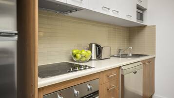 A modern kitchen with a stainless steel refrigerator, a built-in oven, a dishwasher, and a sink.