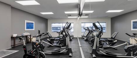 A gym with multiple treadmills, stationary bikes, and a rowing machine.