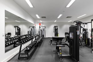 A gym with various exercise equipment, including dumbbells, benches, and weight machines. - Quest Mawson Lakes (Mawson Lakes)