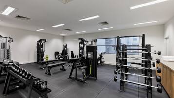 A gym with various exercise equipment, including dumbbells, benches, and weight machines.